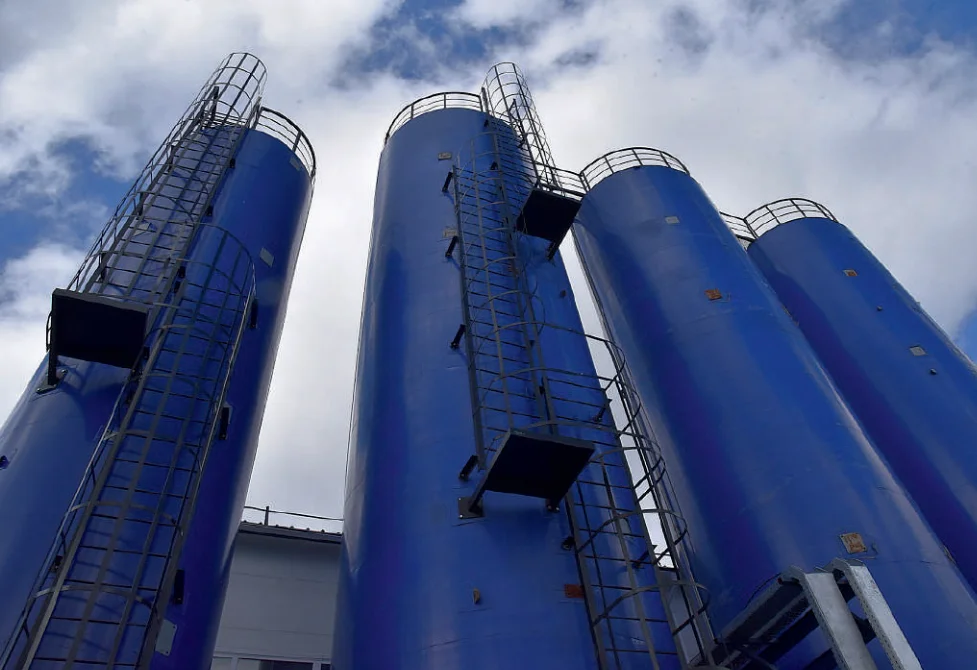 Blaue Silos von Miat Trading und Miat Technologie vor bewölktem Himmel